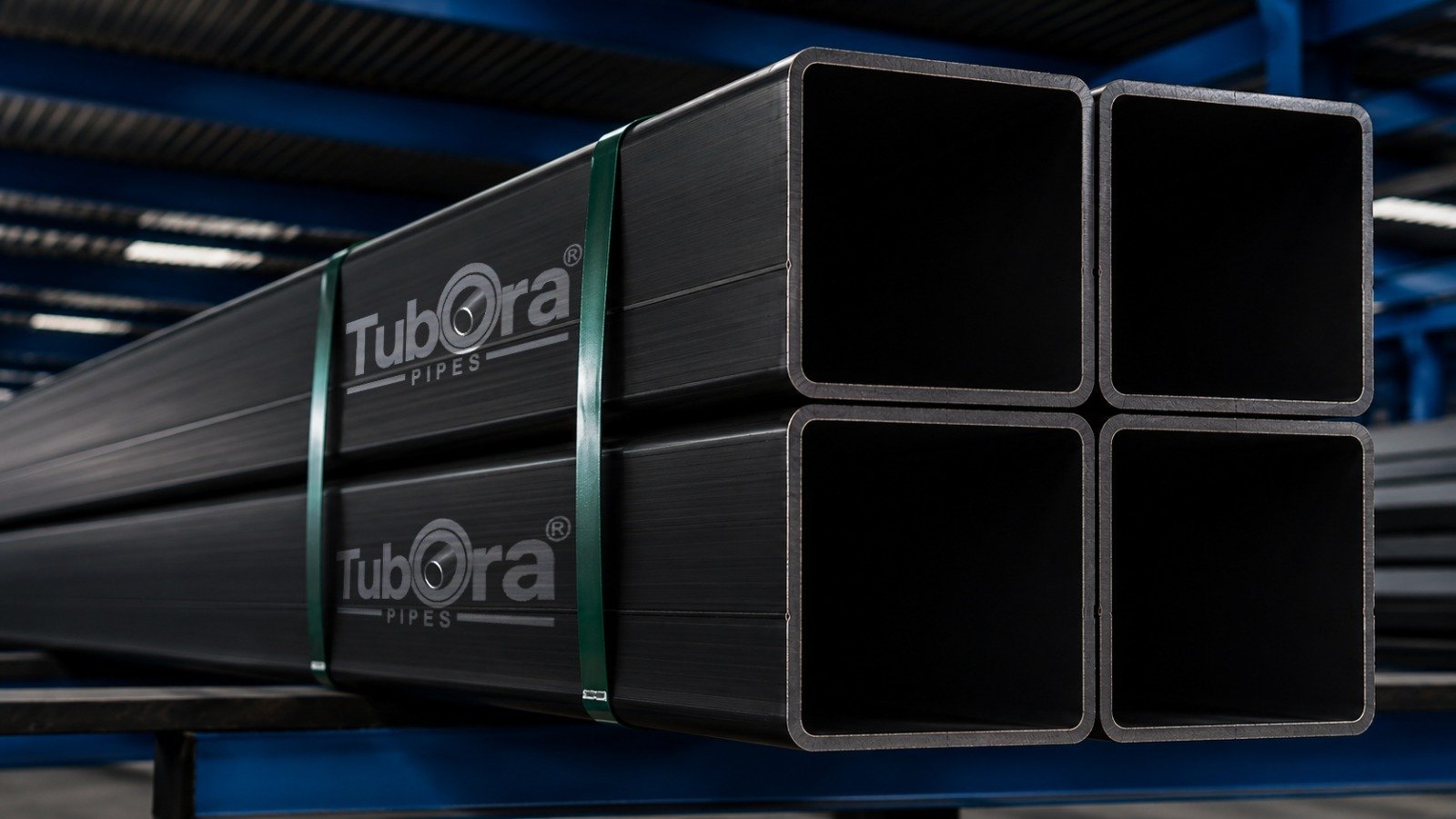 Home 5 Bundled branded square hollow steel sections showing open ends, strapped with green bands in a factory.